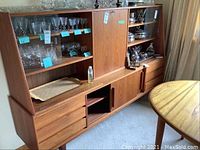 Front view of buffet with glassware (not included) and teak oil bottle