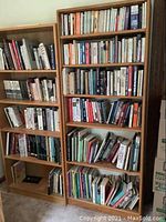 Two large wooden bookcases fully stocked with various collector-related books in hardcover and paperback.