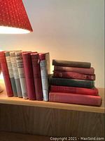 Row of upright hardcover books in red, gray, white cloth