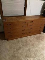 Front view of full dresser showing all drawers and wood finish.