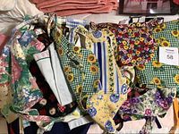 Photo of vintage aprons with various floral and patterned designs bundled together