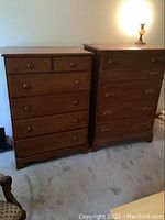 Front view of two vintage wood dressers side by side showing overall design and condition
