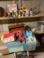 Bin and shelf with assorted vintage Christmas collectibles including boxed ornaments, stocking, and kitchen utensils.