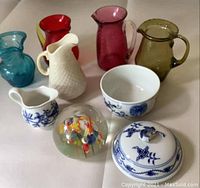 All items arranged together showing variety of small pitchers and decorative items