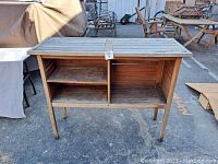 Full front view of the wooden garden workbench showing top surface, legs, and storage compartments.