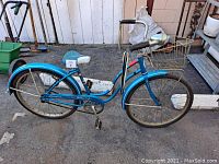 Side view of a vintage blue Schwinn Hollywood Cruiser bicycle showing frame, wheels, seat, and chain areas.