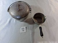 Top view of the Dutch Oven and 1 Quart Sauce Pan showing hammered texture of Dutch Oven and black handle of sauce pan.