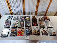 Lot of vintage movie DVDs displayed on a table in rows showing a variety of classic films including musicals and dramas.