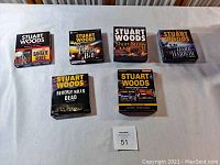 Front view of six Stuart Woods unabridged CD audiobook box sets arranged in two rows showing cover titles and author name.