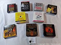 Top-down view of all nine audiobook CD boxed sets arranged in two rows showing front cover artwork and titles.
