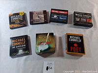 Front view of 7 boxed Michael Connelly audiobooks on CD including Chasing the Dime, Angels Flight, Black Ice, The Overlook, Lost Light, The Poet and a CD Collection set.