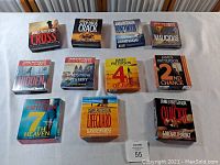 Front view of all 11 James Patterson audiobook CD box sets laid out on a white surface.