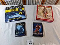 Four educational items about human body and mind on white cloth background: 'Amazing X-Rays: Human Body' book, 'Uncover the Human Body' DVD, 'Secrets of the Mind' DVD, and 'Body Worlds' DVD.