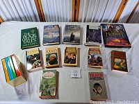 Photo of entire lot spread on a white surface showing all 13 Tolkien books and sets