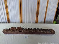 Full view of the complete Western trail wagon model on the wooden base showing the wagons and horses in a line.