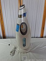 Tall white and gray ultrasonic oscillating humidifier with control buttons and water level window.