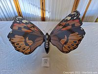 Top-down view of large antique wooden butterfly wall mount with painted wings in autumn colors.