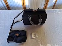 View of the black purse with an adjustable shoulder strap and purse bag organizer on a white surface.