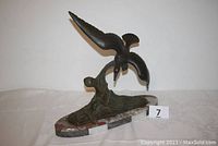 Front and side view of bronze seagull statue on marble base showing overall form and condition.