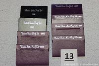 Eight U.S. Proof Sets from 1980, 1982, 1985, 1986, 1987, 1989, 1990, 1991 in original packaging envelopes.