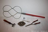 Lot of antique household tools and metal bird ornament including rug beater, ice chippers, curling iron, button hook, and metal bird.