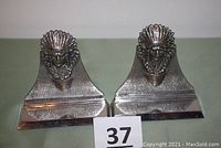 Pair of stainless steel Native American chief bookends front view showing detailed feather headdresses and necklace on chief busts.