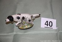 Full side view of the black and white English Setter bottle opener showing the hand painted enamel and pointing dog figure on a grassy base.