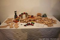 Full set display of track pieces arranged with trains and accessories on table.