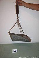 Full view of the metal hanging scale with the basket suspended.