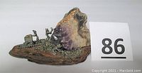 Front angle showing quartz stone with gold vein and metal miner figurines on wooden base