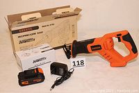 Erebus orange and black reciprocating saw with battery and charger displayed outside product box.