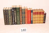 Photo shows a row of vintage hardback books lined up, featuring decorative covers and spine titles by various classic authors.