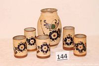 Full set including one pitcher and five mugs with floral patterns viewed from front.