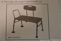 Illustration of fully assembled grey-silver Drive transfer tub bench with backrest and arm supports, showing seat dimensions and design details