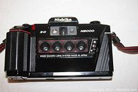 Front view of the Nishika N8000 3D camera showing four fixed 30mm lenses in a horizontal row and visible branding.