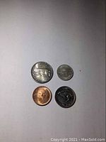Four 1967 US coins laid out showing quarter, dime, nickel, and penny.