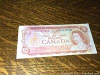 Front view of the 1974 Canadian 2 dollar bill showing Queen Elizabeth II portrait, serial number AR2257530, and denomination details.