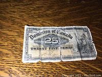 Full view of a heavily worn 25 cent bill from Dominion of Canada dated January 1900, showing creases and tears.