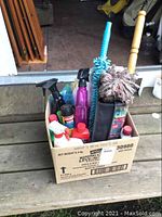 Wide view of the box containing various spray bottles, cleaning products, brushes, and cleaning tools for car care