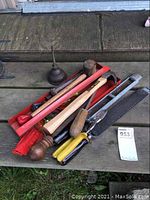 Metal tray with various hand tools including wooden handled files, mallet, screwdriver and oiler container on wood deck