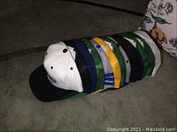 Side view of stacked ball caps showing multiple colors and mesh backs