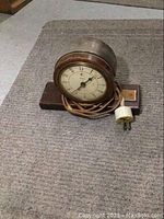 Full view of vintage Telechron electric clock with cord and plug, wooden base