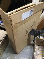 Closed box containing the McCormicks store display rack packaging, showing shipping labels and wear on the box.