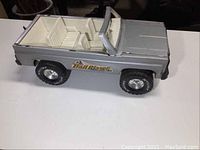 Side profile photo showing silver body, white interior seats, large black tires with silver rims, and Trail Blazer decal.