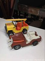 Both toy Jeeps placed next to each other showing size and color contrast
