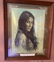 Framed Bill Hampton Indian print showing Native American woman in traditional attire with caption below, in wooden frame with decorative mat corners.