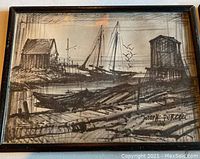 Framed black and white sketch depicting two sailboats docked between two small wooden buildings on a shoreline, signed Joseph Purcelli.
