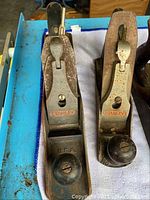 Two vintage Stanley Wood Planes marked No. 3 and No. 9, showing front knobs and lever caps with visible Stanley branding in red lettering.