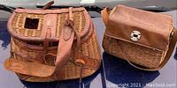 Photo showing both large and small fishing creels side by side, highlighting leather tops, wicker construction, and leather straps.