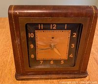Front view of the Telechron mantle clock showing wooden case and clock face with wear and details.